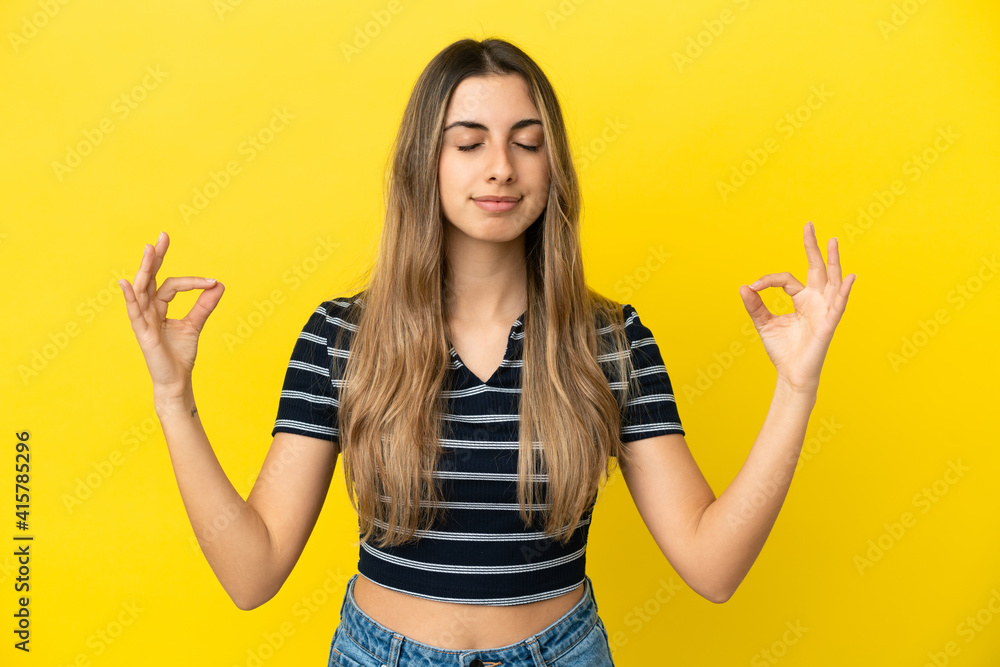 Young caucasian woman isolated on yellow background in zen pose Young caucasian woman isolated on yellow background in zen pose