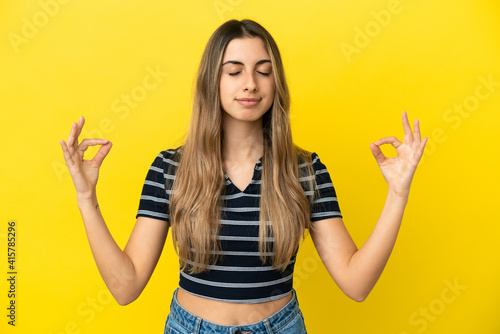 Young caucasian woman isolated on yellow background in zen pose