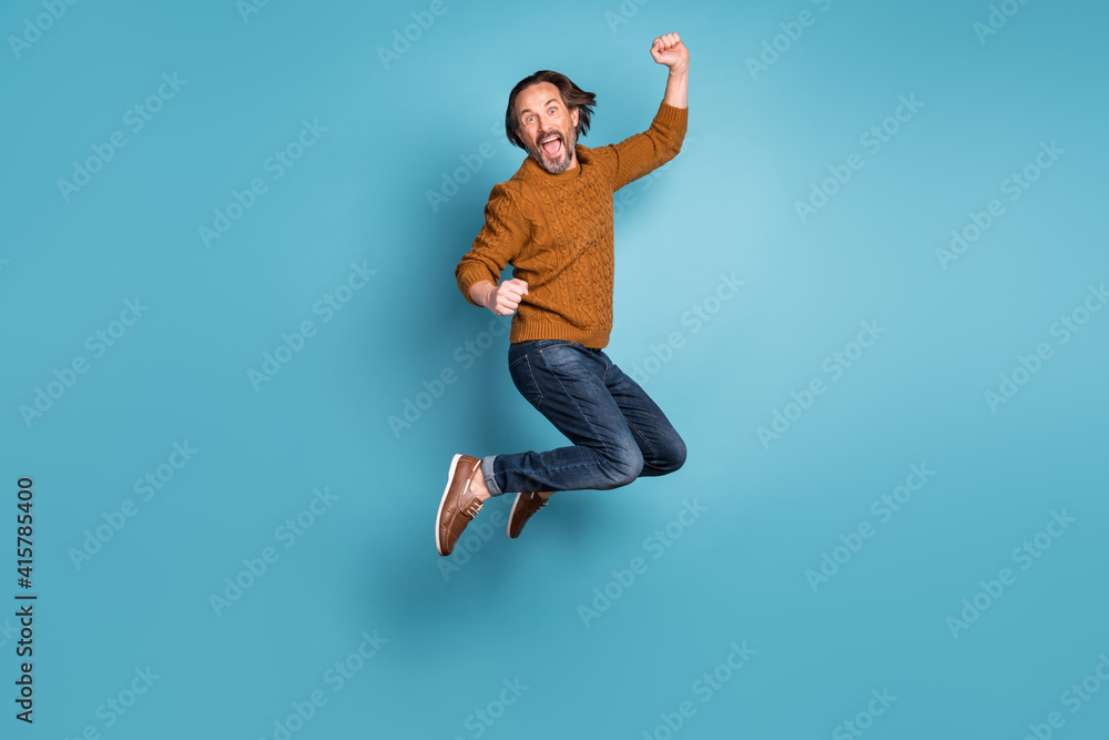 Fototapeta premium Full size photo of mature handsome excited crazy smiling man jumping in success victory isolated on blue color background