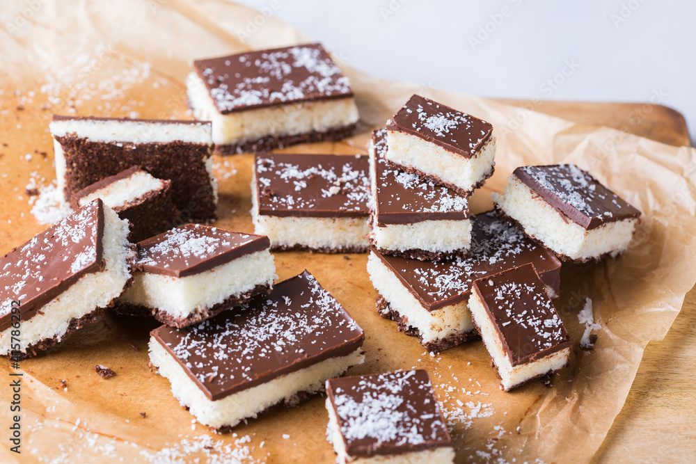 Organic raw vegan coconut bars with chocolate on kitchen table Organic raw vegan coconut bars with chocolate on kitchen table