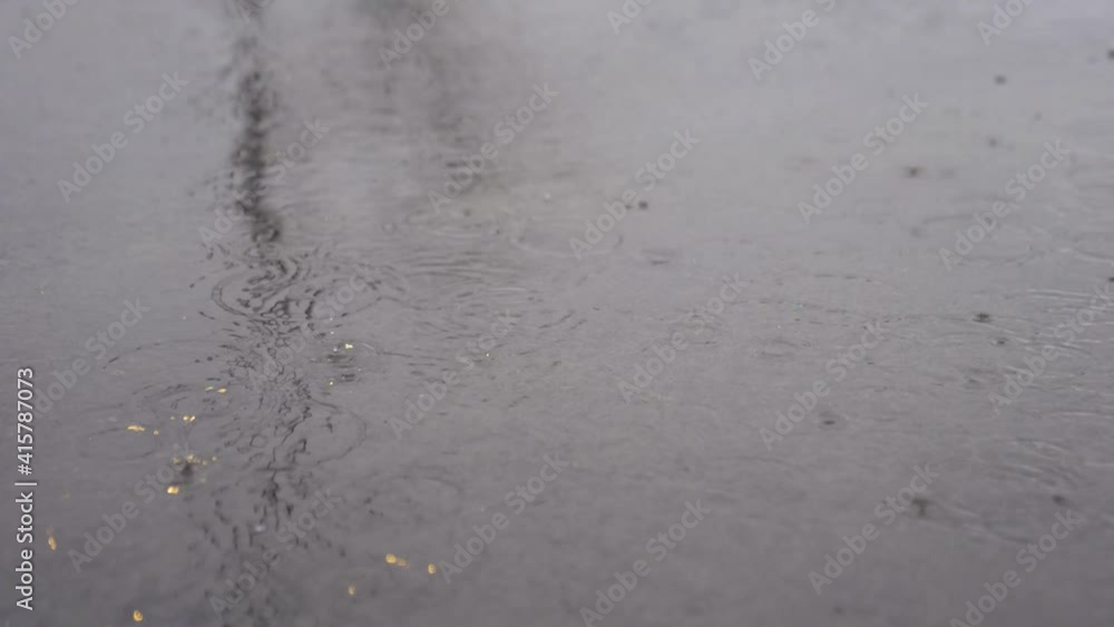 Raindrops Hitting Pavement during a light rain storm in slow motion Raindrops Hitting Pavement during a light rain storm in slow motion