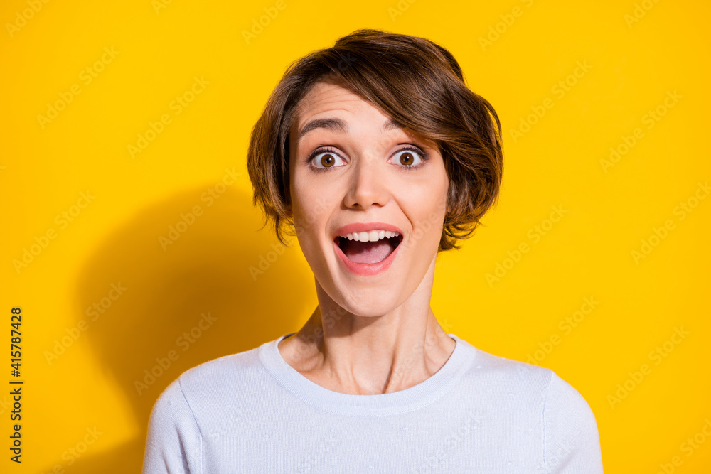 Photo portrait of amazed excited girl with open mouth isolated on bright yellow colored background Photo portrait of amazed excited girl with open mouth isolated on bright yellow colored background