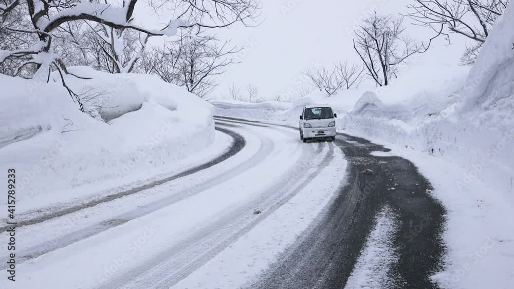 雪道のカーブを走る軽トラック 雪道のカーブを走る軽トラック