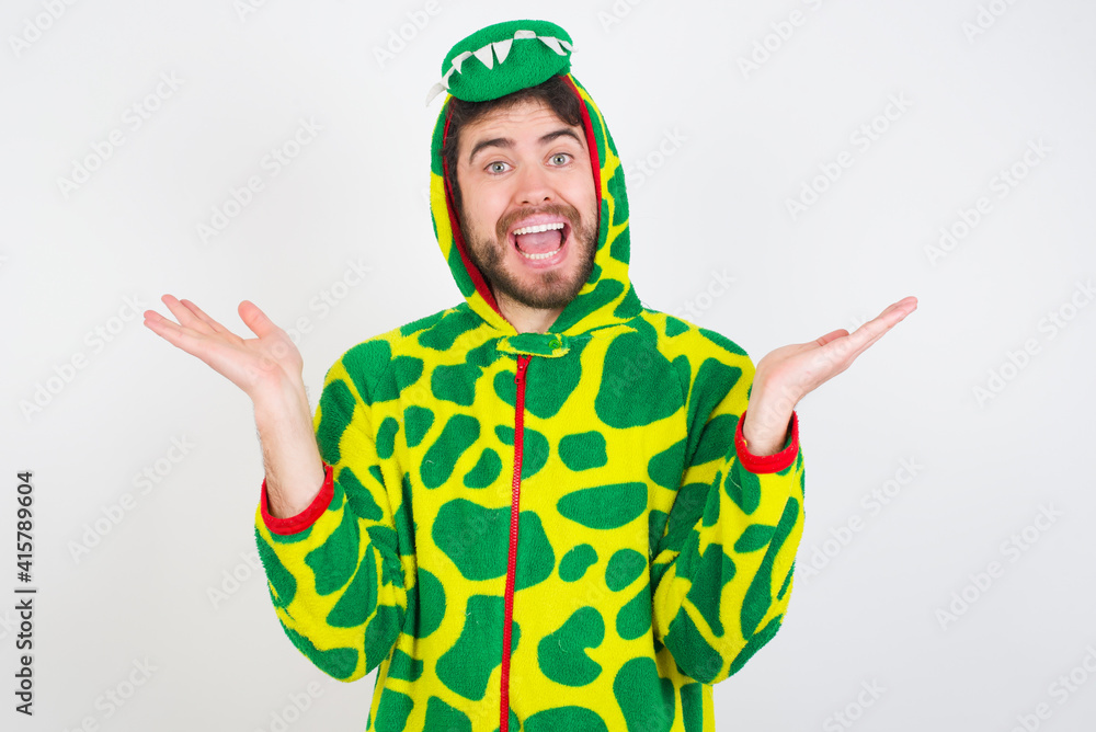 Fototapeta premium young caucasian man wearing a pajama standing against white wall celebrating crazy and amazed for success with arms raised and open eyes screaming excited. Winner concept