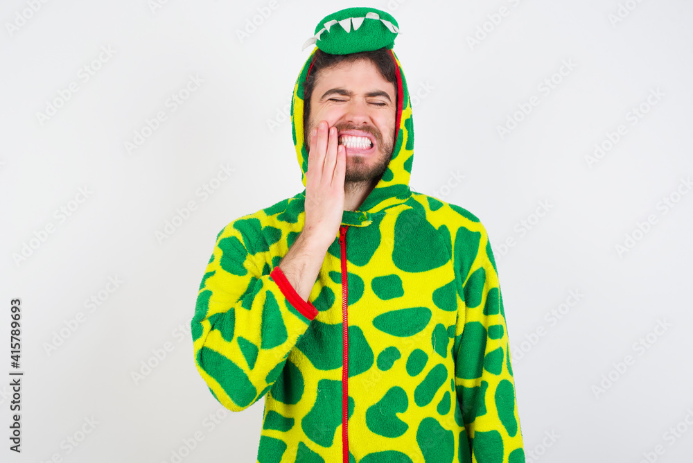 Fototapeta premium young caucasian man wearing a pajama standing against white wall touching mouth with hand with painful expression because of toothache or dental illness on teeth.