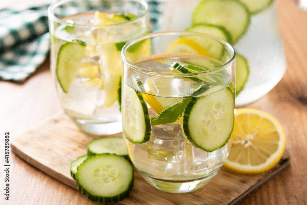 Sassy water or water with cucumber and lemon on wooden table Sassy water or water with cucumber and lemon on wooden table