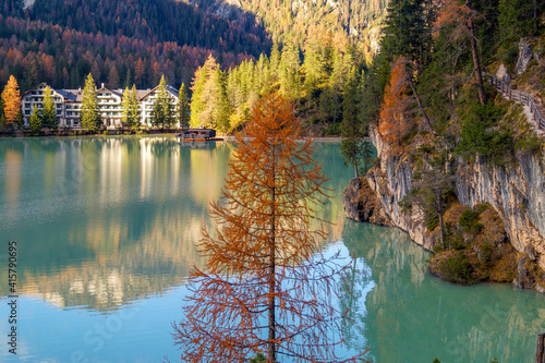 Fototapeta Naklejka Na Ścianę i Meble -  Autumn at Lake Braies, northern Italy. Colourful needles on larch tree against turquoise water surface. Mountain tourist destination.
