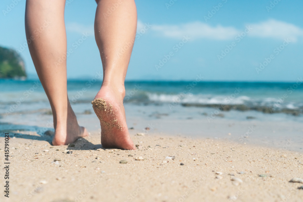 Woman feet walk slow life and relax on sand tropical beach with blue sky background. Woman feet walk slow life and relax on sand tropical beach with blue sky background.