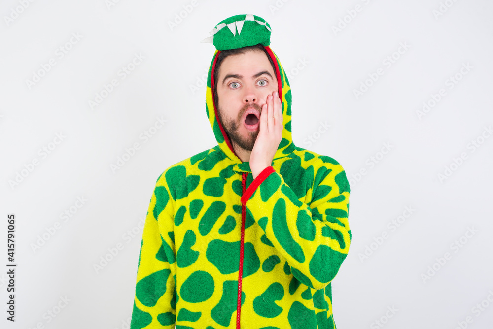 Fototapeta premium Shocked young caucasian man wearing a pajama standing against white background looks with great surprisment being very stunned, astonished with unexpected news, Facial expressions concept.