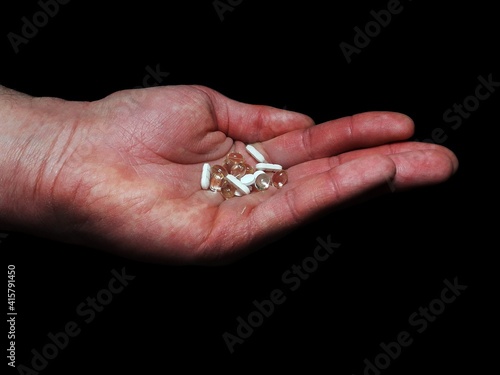 Antidepressants drug pills on man palm on black background