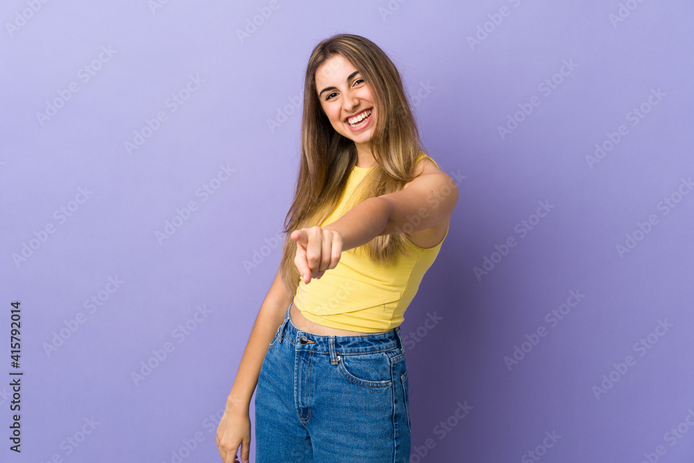 Young woman over isolated purple background pointing front with happy expression Young woman over isolated purple background pointing front with happy expression