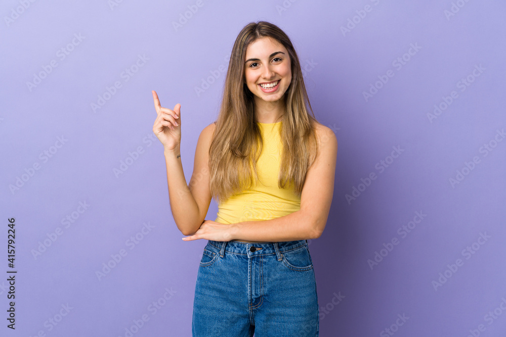 Young woman over isolated purple background happy and pointing up Young woman over isolated purple background happy and pointing up