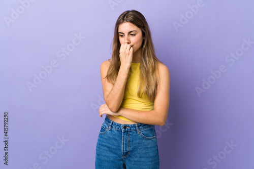 Young woman over isolated purple background having doubts