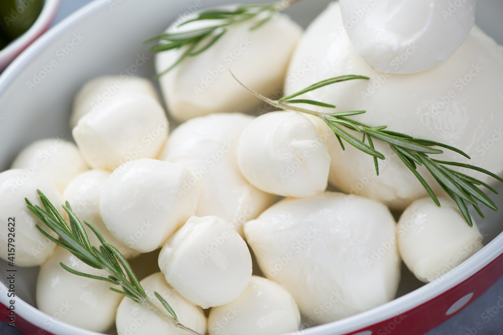 Mozzarella balls of different sizes with fresh rosemary, close-up, selective focus, horizontal shot Mozzarella balls of different sizes with fresh rosemary, close-up, selective focus, horizontal shot