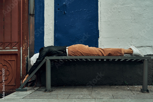 The girl lies on a metal bench. Fatigue and the aftermath of the party. Photo session in the city