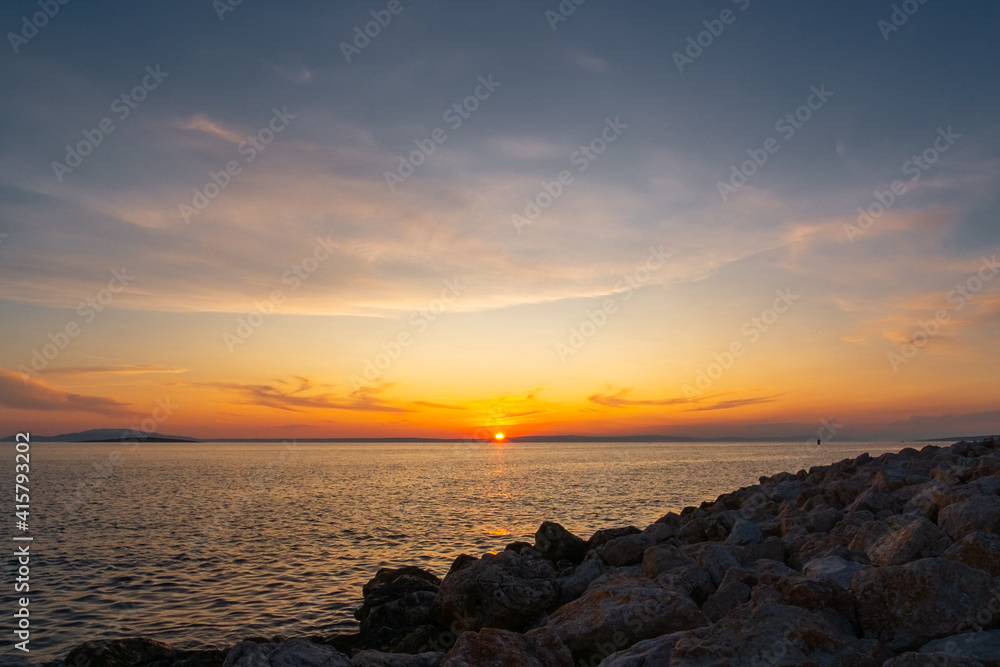 Multi-coloured twilight sky above vast water surface. Sun rising behind mainland and Adriatic sea. Romantic scene. Multi-coloured twilight sky above vast water surface. Sun rising behind mainland and Adriatic sea. Romantic scene.