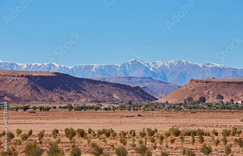 View of the green plain and snowy Atlas Mountains photo