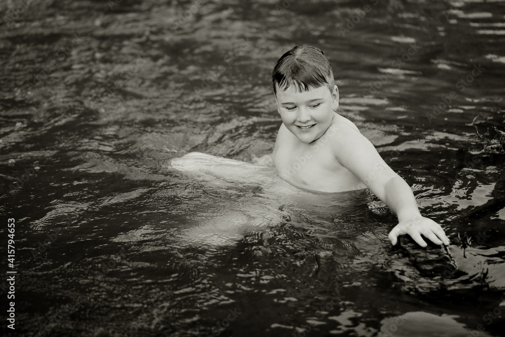 Fototapeta premium Black and white image of boy swimming in natural swimming hole in central New South Wales, Australia