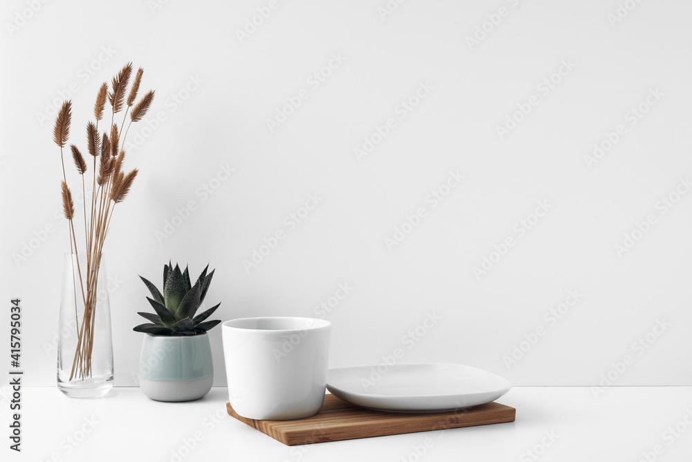 White cup and saucer on a wooden board, white background. Eco-materials and design. Copy space, mock up.