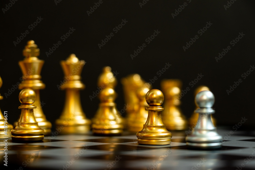 Silver pawn in chess game face with the another gold team on black background (Concept for company strategy, business victory or decision) Silver pawn in chess game face with the another gold team on black background (Concept for company strategy, business victory or decision)