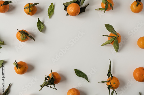 Frame with copy space. Oranges  tangerines with leaves pattern. Fresh healthy fruits  food background. Flatlay  top view.