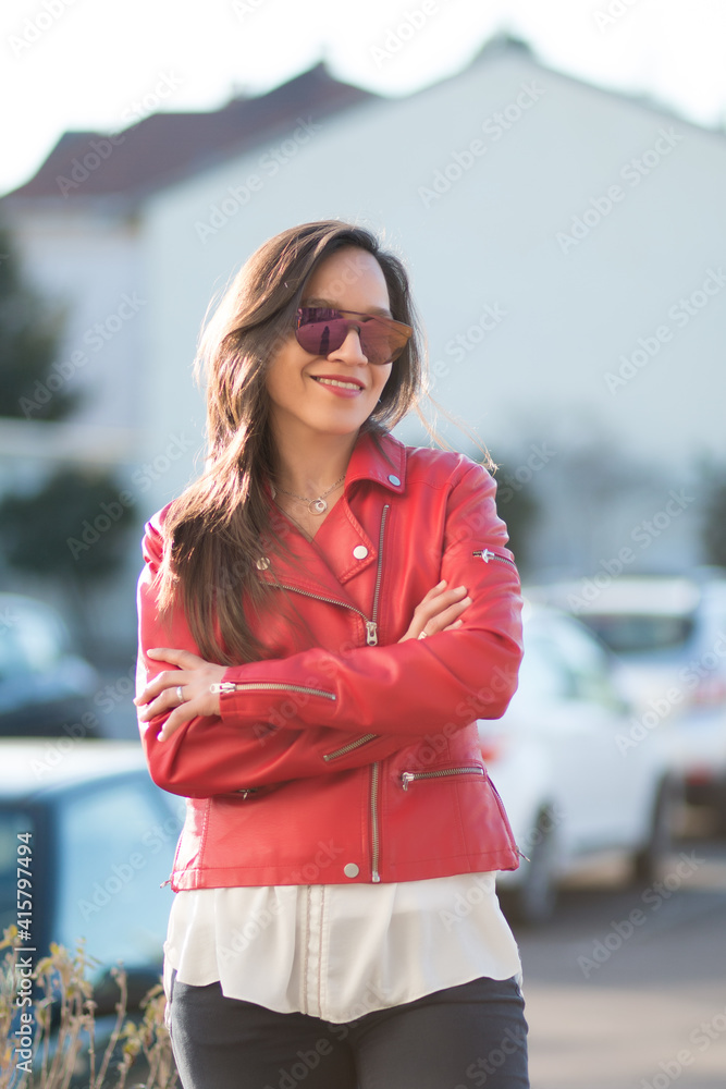 Happy and elegant woman in red wearing a smartphone standing on the street Happy and elegant woman in red wearing a smartphone standing on the street