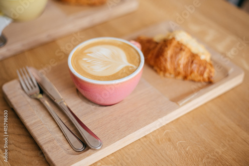 Tasty croissants with jot coffee on wooden background Fototapeta