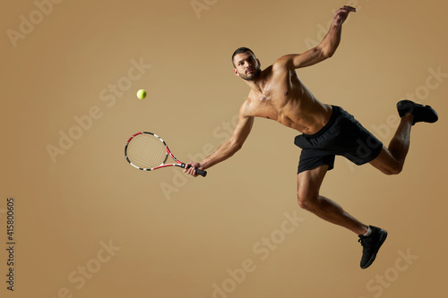 Adorable athlete man wearing sportswear playing in tennis in room indoors © Friends Stock