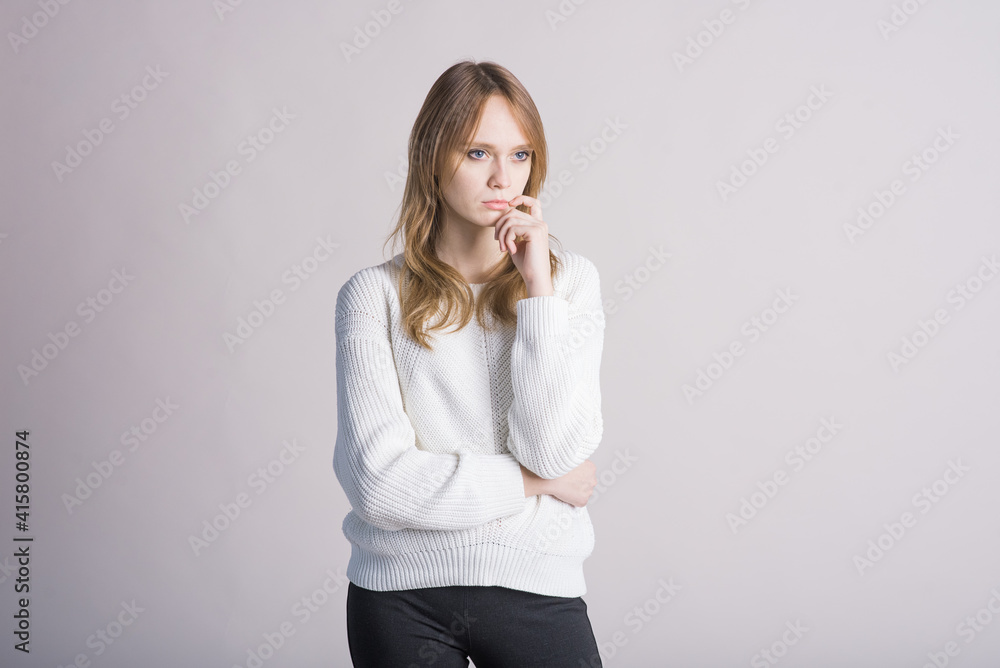 Portrait of a stylish girl on a white background in the studio who thinks Portrait of a stylish girl on a white background in the studio who thinks