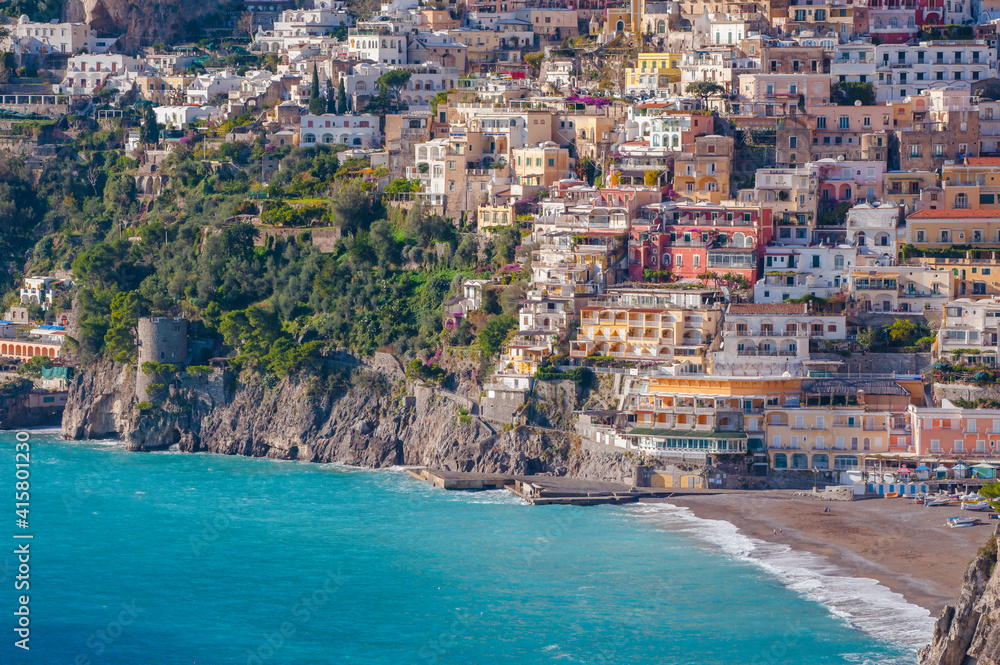 Sandy beach, colorful houses and blue sea in on hills leading down to coast, Campania, Italy