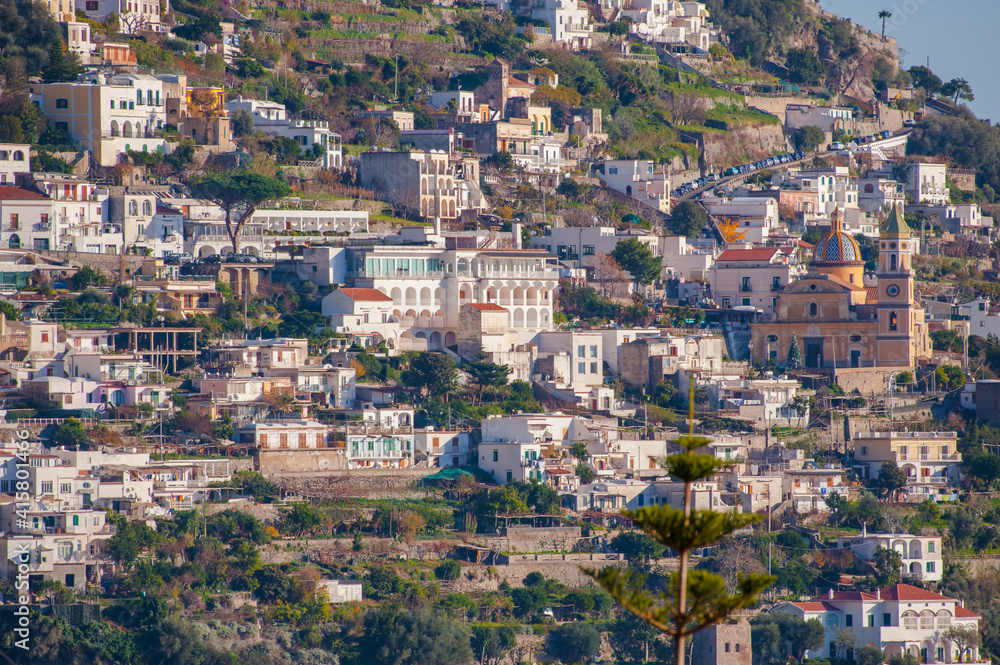 Beautiful Church with a golden dome and green trees in Amalfi on hills, Campania, Italy.