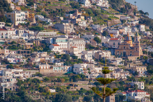 Beautiful Church with a golden dome and green trees in Amalfi on hills, Campania, Italy. © Artur