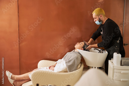 Obraz na plátně Female reclining in the chair during the shampooing procedure