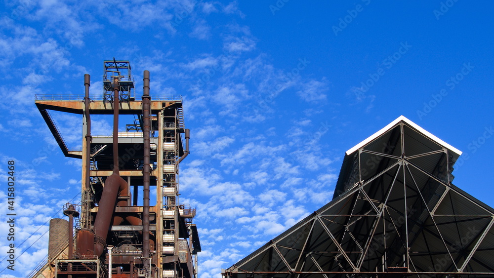 Stillgelegte Industrieanlage mit leerstehender Lagerhallt im Ruhrbebiet in Deutschland vor blauem Himmel im Sommer