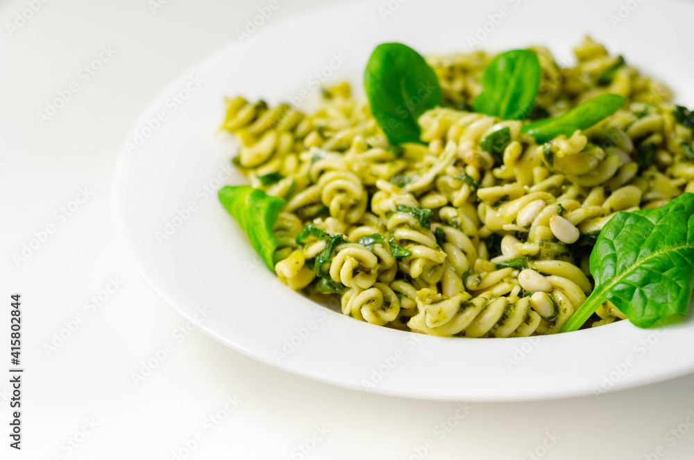 Pesto and pine nut pasta salad, fusilli pasta with regato cheese and baby spinach coated in basil pesto Pesto and pine nut pasta salad, fusilli pasta with regato cheese and baby spinach coated in basil pesto