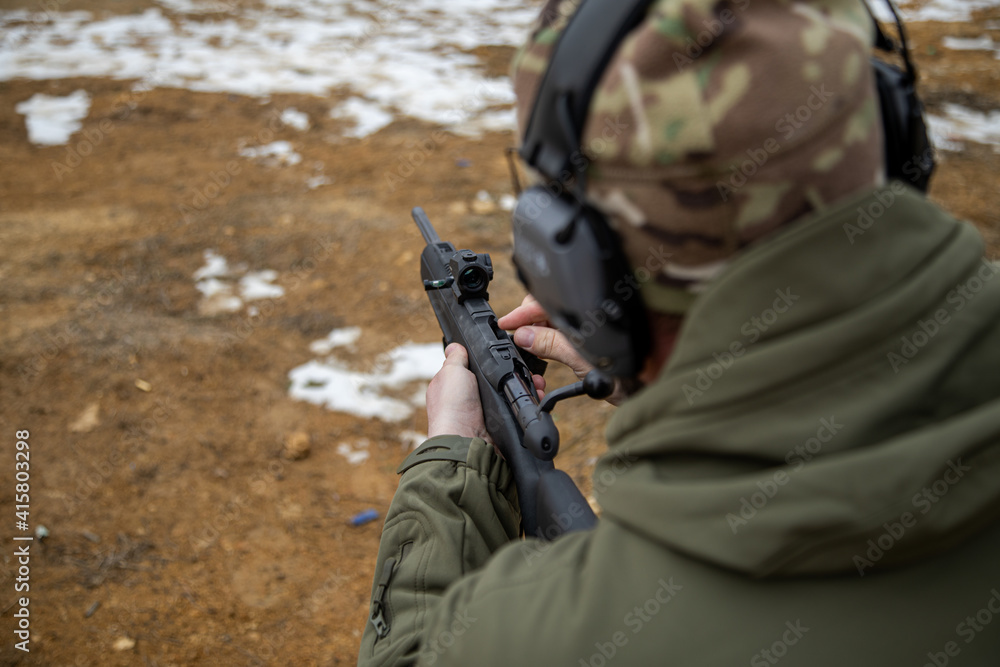 Shooter loads rifle, focus on collimator sight, soft focus Stock Photo ...