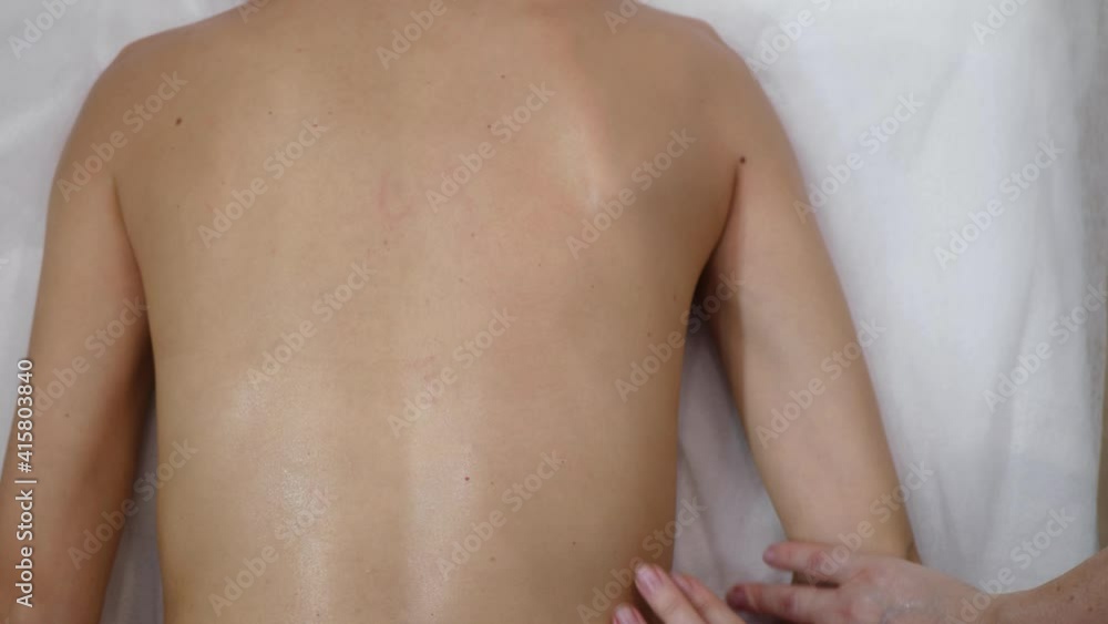 Female hands professionally massage the scapula top view. Woman massage therapist doing shoulder massage Female hands professionally massage the scapula top view. Woman massage therapist doing shoulder massage