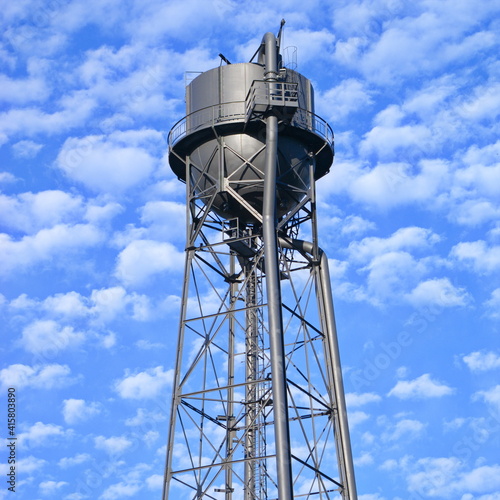 Wassteturm einer stillgelegten Industrieanlage vor blauem Wolkenhimmel bei Sonnenschein im Ruhrpott