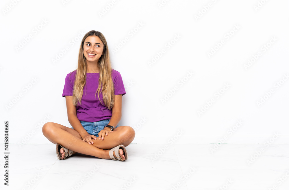 Young hispanic woman sitting on the floor thinking an idea while looking up Young hispanic woman sitting on the floor thinking an idea while looking up