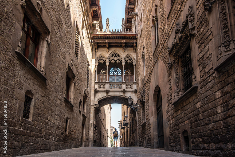 A male traveler with a backpack visiting the Gothic quarter of the city of Barcelona, Spain 