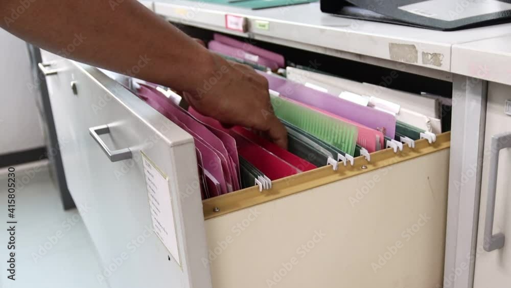 Hand of Man Search files document in a file cabinet in work office, concept business office life.