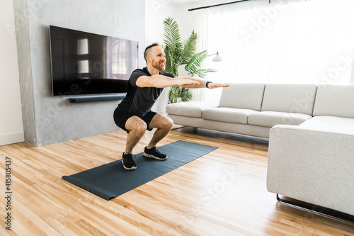 Fototapeta Naklejka Na Ścianę i Meble -  Man on a mat doing some exercise at home
