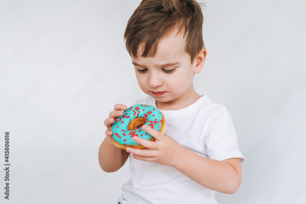Funny cute toddler boy with donut on the white background Funny cute toddler boy with donut on the white background