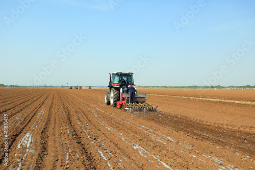 Farmers drive planters to plant Plastic Mulched peanuts in North China