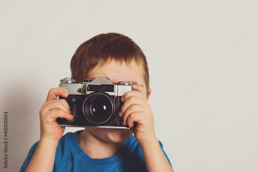 Small child taking photo with retro film camera. Old technology concept with copy space. Small child taking photo with retro film camera. Old technology concept with copy space.