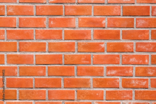 Surface orange brick wall pattern close-up.