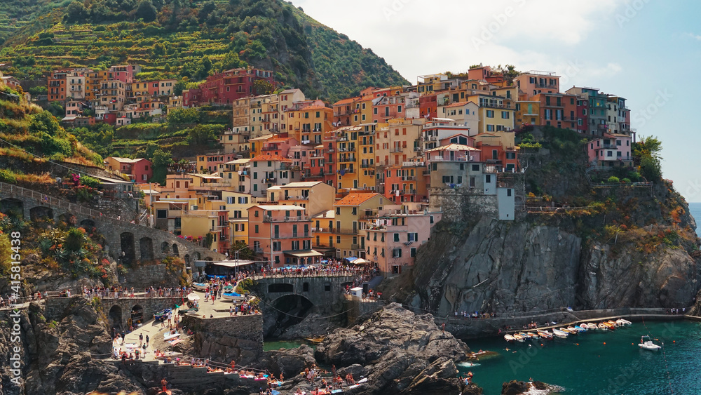 View of Manarola from the hiking trail. Neat European houses on the rock of the peninsula.