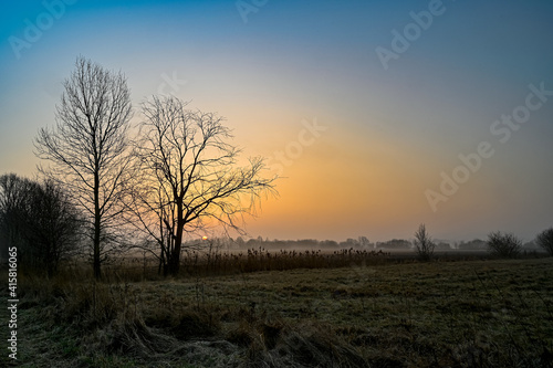 orange sunrise over agriculture fields a misty morning