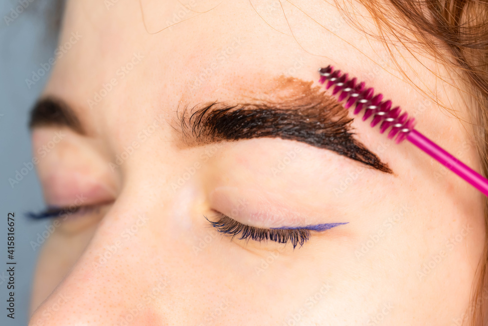 Young Caucasian Woman on the brow beauty procedures. Professional care for face. Brows coloring, wax and lamination. 