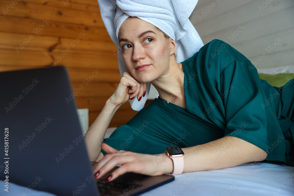 Young woman working at the computer after a shower Young woman working at the computer after a shower